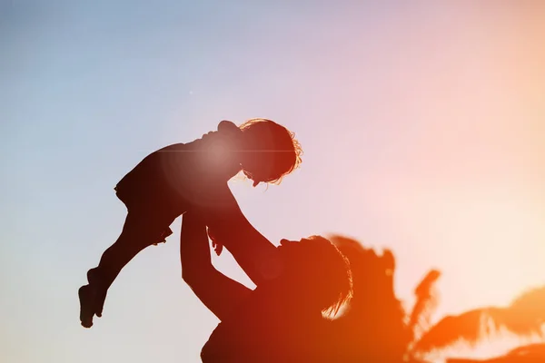 Silhouet van familie spelen op sunset beach — Stockfoto