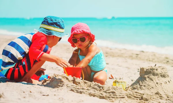 Barn leker med sand på sommaren stranden — Stockfoto