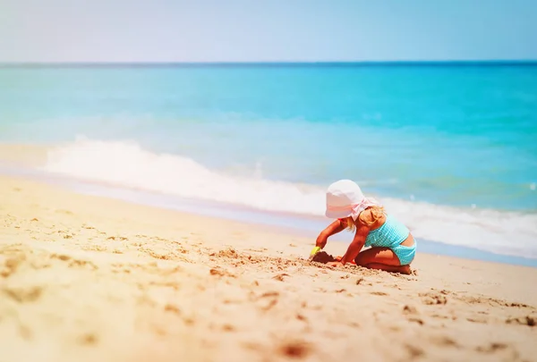 Söt liten flicka leka med sand på stranden — Stockfoto