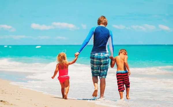 Padre e due bambini a piedi sulla spiaggia — Foto Stock