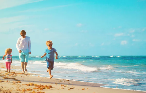 Vader met kleine zoon en dochter lopen op strand — Stockfoto