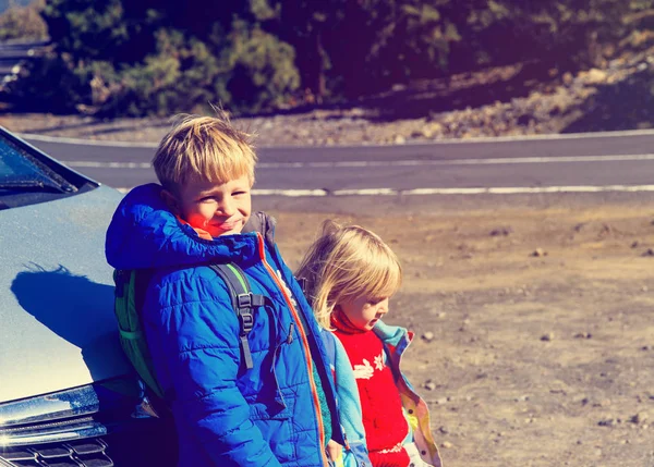Маленький хлопчик і дівчинка-малюк подорожують на машині в дорозі — стокове фото