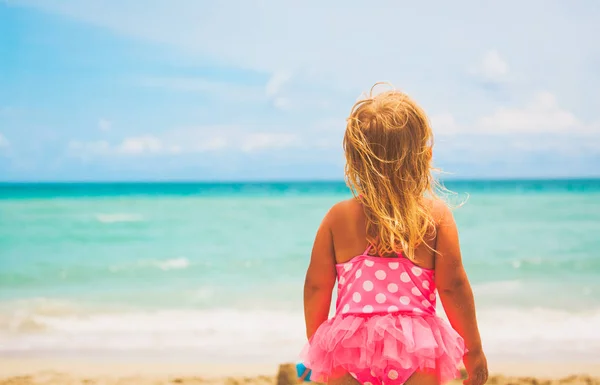 Holčička se dívá na pláži, tropickou dovolenou koncept — Stock fotografie