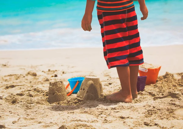 Menino brincar com areia na praia — Fotografia de Stock