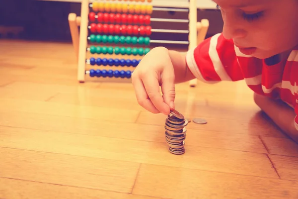 Маленький хлопчик рахує свої заощадження — стокове фото