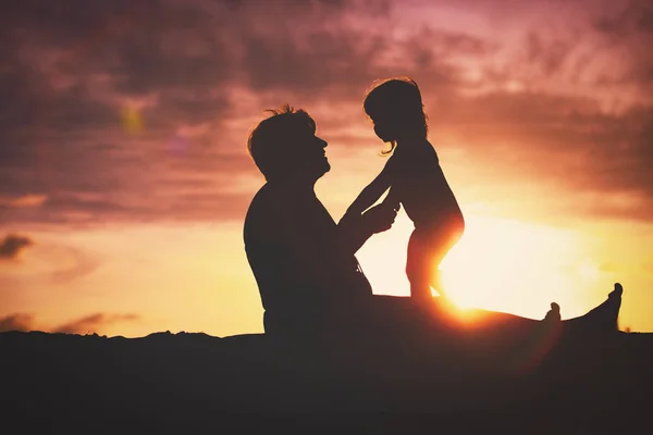 Silhouette de grand-mère et petite petite-fille jouent à la plage du coucher du soleil — Photo