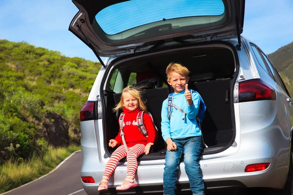 Little boy and girl travel by car on road in nature — Stock Photo, Image