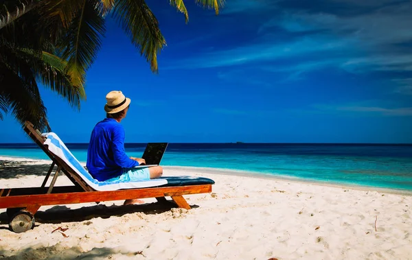 Fjärrkontrollen fungerar - mannen med laptop på stranden — Stockfoto