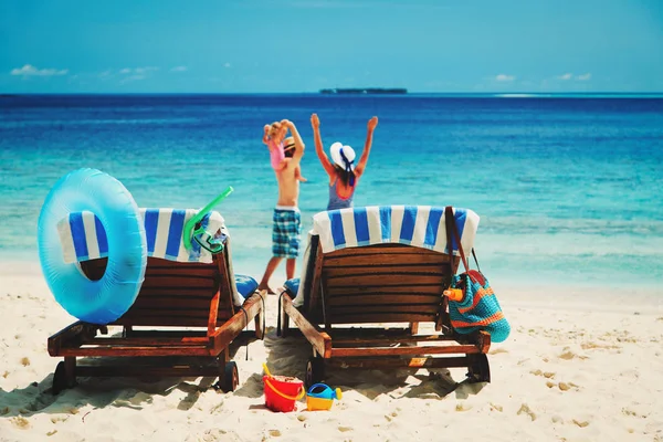 Família feliz com criança pequena na praia tropical — Fotografia de Stock