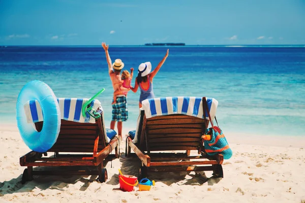 Familia feliz con un niño pequeño en la playa tropical — Foto de Stock