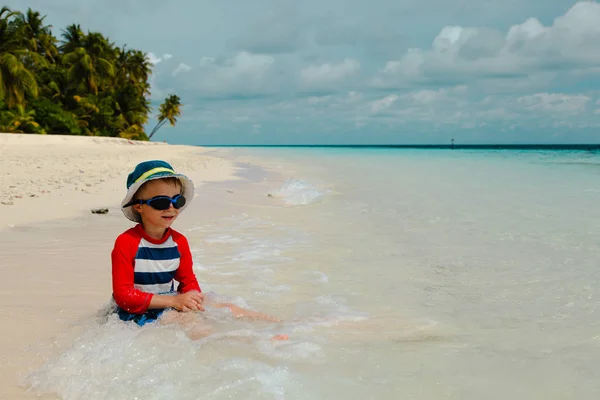 Menino feliz relaxado na água na praia — Fotografia de Stock