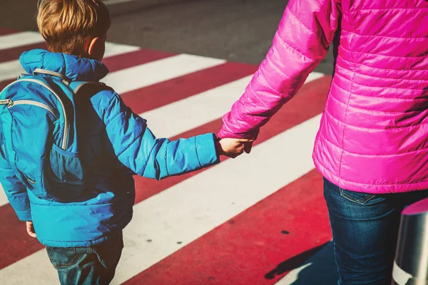 Mother holding hand of little son with backpack on the road — Stock Photo, Image
