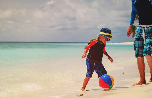 Vader en zoon spelen bal op strand — Stockfoto