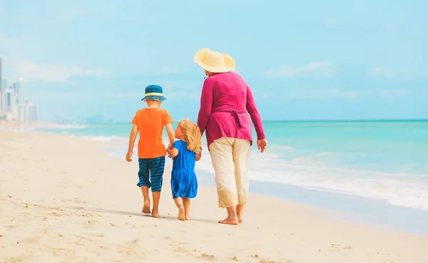 Oma met kinderen - kleine jongen en meisje-op strand — Stockfoto