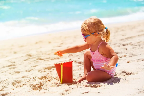 Bonito menina jogar com areia na praia — Fotografia de Stock