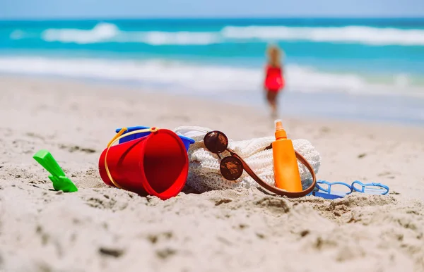 Strand nyaralás koncepció - táska, a napkrém, a játékok és a flip papucs a tengerparton — Stock Fotó