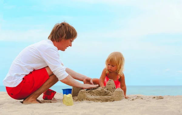 Vader en dochtertje spelen met zand op strand — Stockfoto