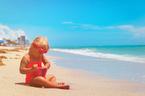 Dziewczynka gry z wody i piasku na plaży — Zdjęcie stockowe