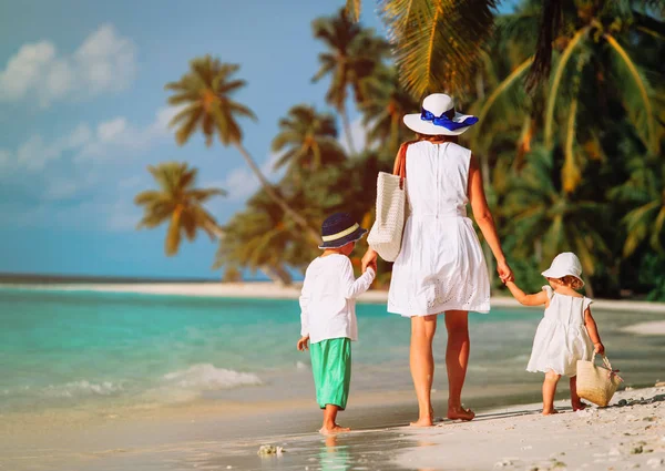 Moeder en twee kinderen walking op strand — Stockfoto