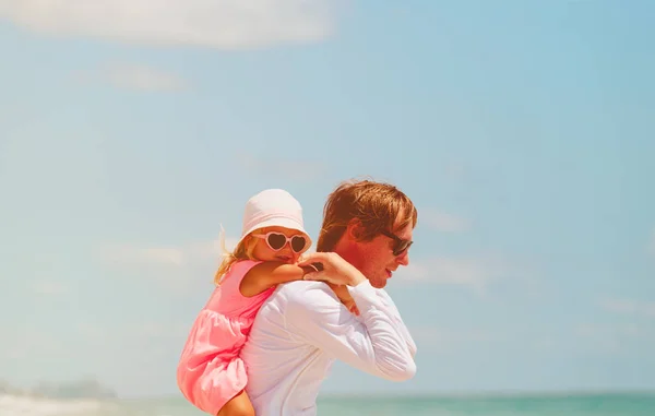 Happy father and little daughter at sky on beach — Stock Photo, Image