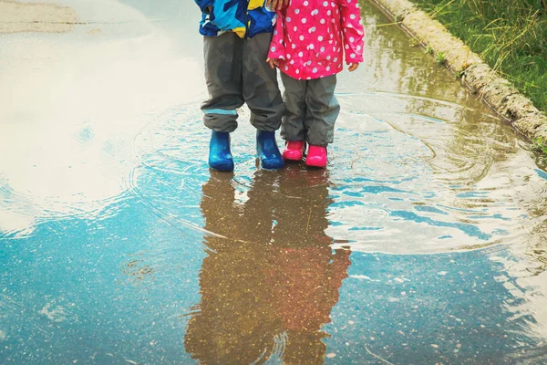 Маленький хлопчик і дівчинка грають у водяній калюжі — стокове фото