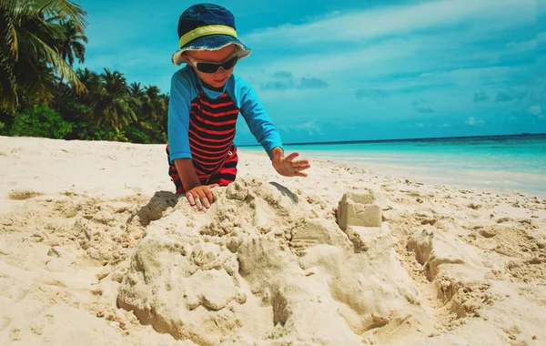 Küçük çocuk tropik sahilde kum ile oynamak — Stok fotoğraf