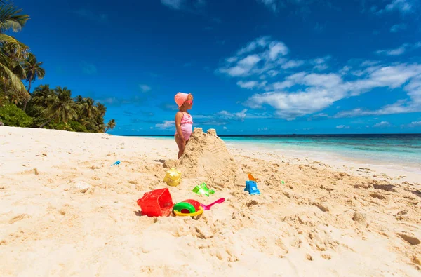 Küçük kız sahilde kum ile oynamak — Stok fotoğraf