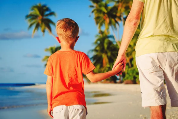 Zoontje vaders hand houden op strand — Stockfoto