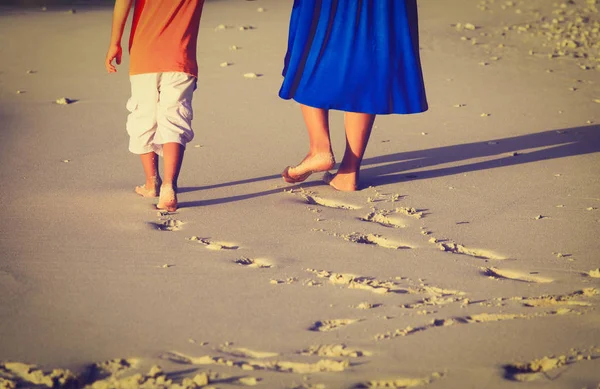 Matka i syn spacerujący po plaży pozostawiając ślady stóp w piasku — Zdjęcie stockowe