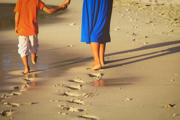 Matka a syn kráčející po pláži zanechávající stopu v písku — Stock fotografie
