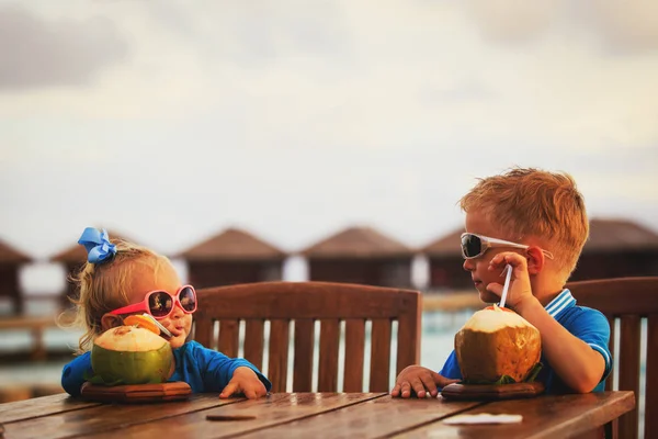 Niño y niña bebiendo coctel de coco en la playa — Foto de Stock