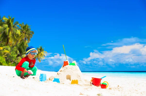 Menino brincar com areia na praia tropical — Fotografia de Stock