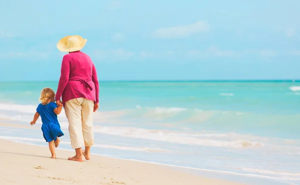Gelukkig grootmoeder met kleine kleindochter wandeling op het strand — Stockfoto