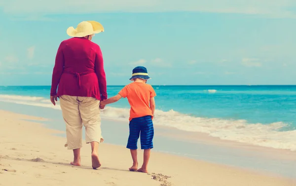 Gelukkig oma met kleinzoon lopen op strand — Stockfoto