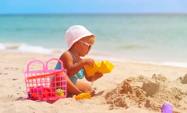 Carino bambina giocare con sabbia sulla spiaggia — Foto Stock