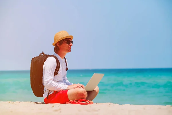 Fjärrkontrollen fungerar - mannen med laptop på stranden — Stockfoto