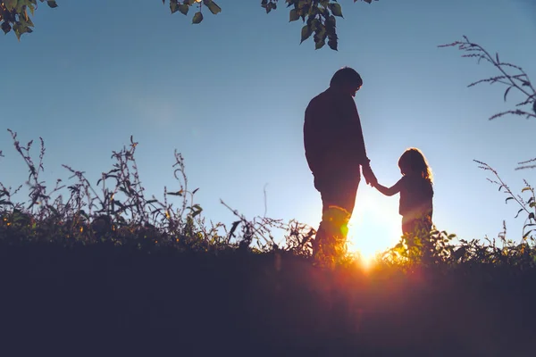 Vader met kleine dochter wandeling in de zonsondergang — Stockfoto