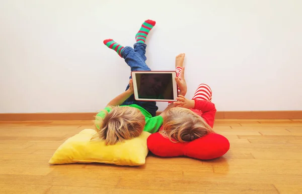 Kleine Jungen und Mädchen schauen zu Hause entspannt auf das Touchpad — Stockfoto