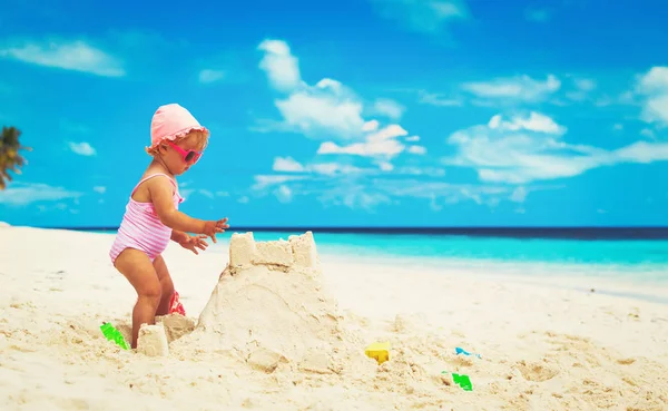 小さな女の子はビーチで砂で遊ぶ — ストック写真