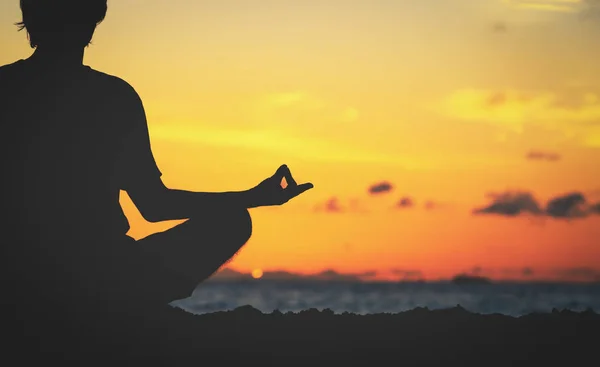 Спокойствие и йога практикующие на закате — стоковое фото