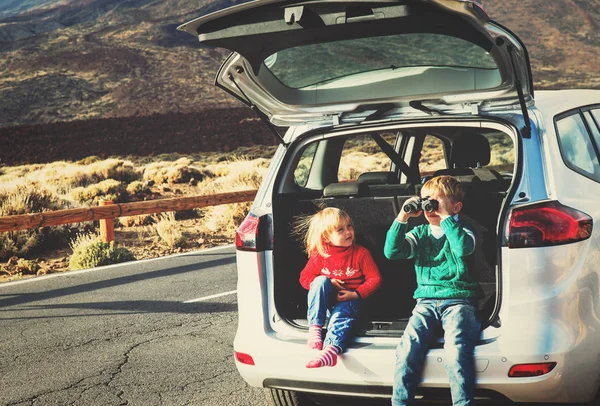 Little boy and girl looking through binoculars travel by car — Stock Photo, Image