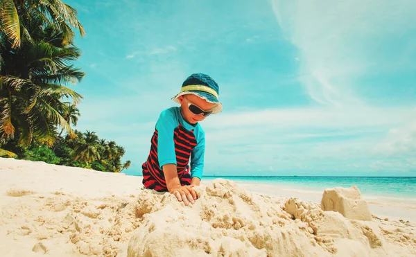 Küçük çocuk tropik sahilde kum ile oynamak — Stok fotoğraf