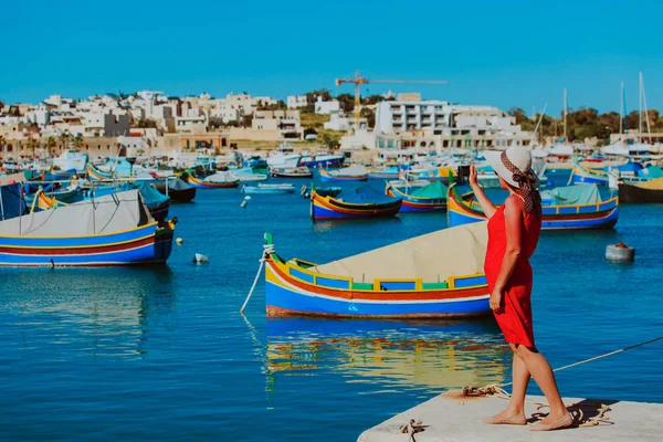 Turista haciendo foto de barcos trandicionales malteses — Foto de Stock