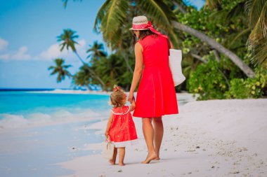 Anne ve küçük kızı sahilde yürüyor.