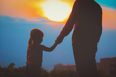 Baba ve kızı günbatımında elele siluet