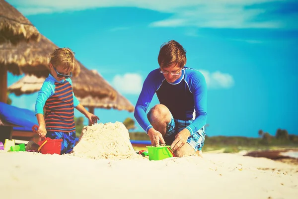 Pai e filho construindo castelo de areia na praia — Fotografia de Stock