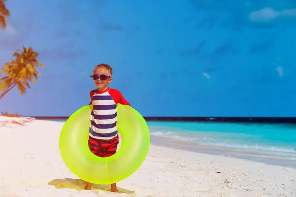 Bambino con anello galleggiante sulla spiaggia tropicale — Foto Stock