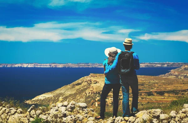 Jovem casal caminhadas em montanhas no mar — Fotografia de Stock