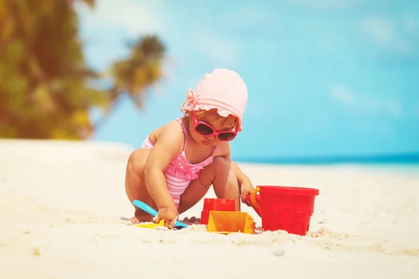 Tatlı küçük kız kumsalda kumla oynuyor. — Stok fotoğraf