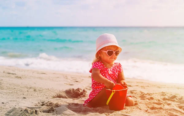 Mignonne petite fille jouer avec le sable sur la plage — Photo